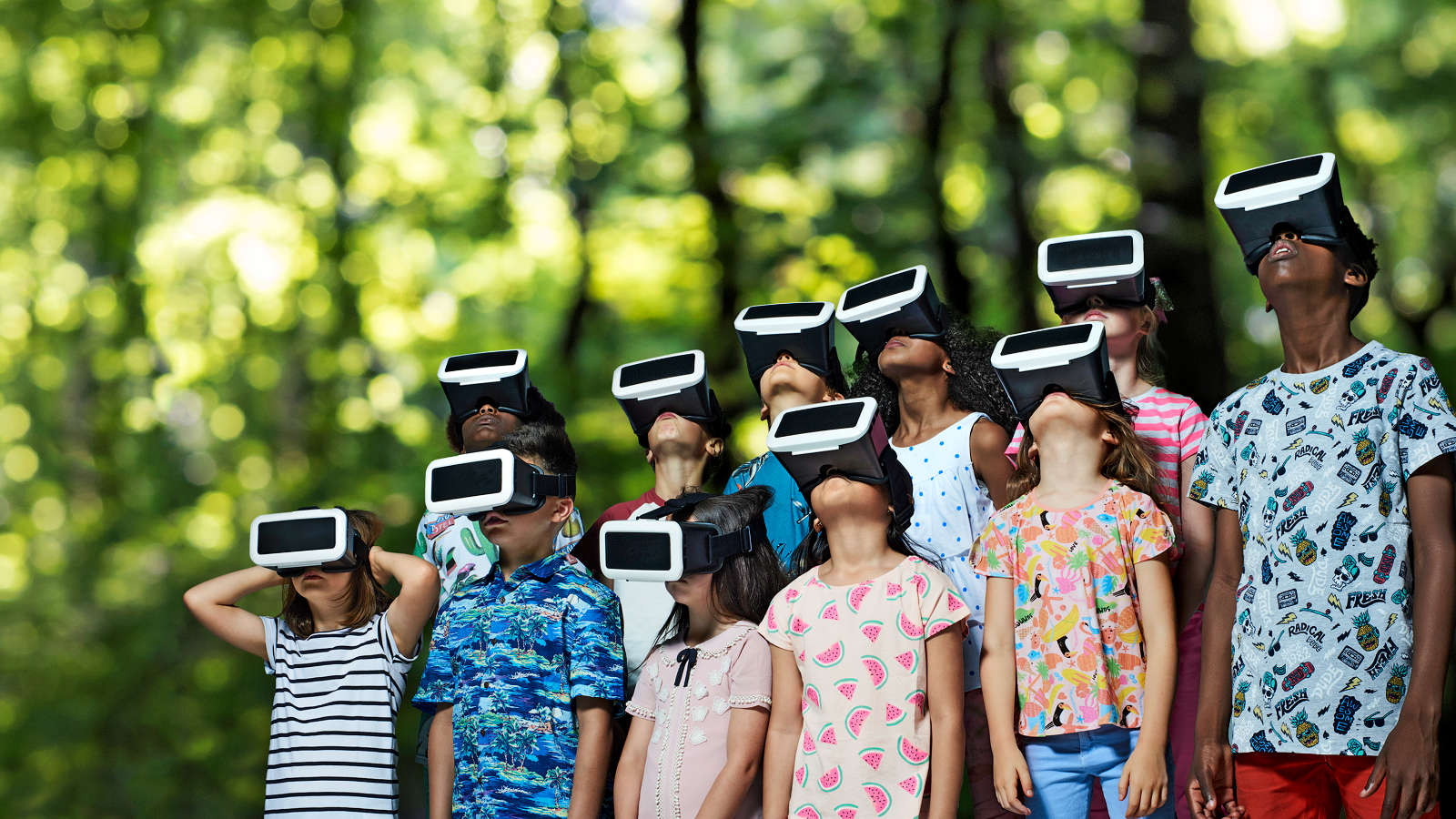 Gruppe von Kindern blickt durch Virtual Reality Headsets